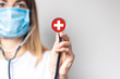 female doctor in a medical mask holds a stethoscope on a light background. Added flag of Switzerland. Concept medicine, level of medicine, virus, epidemic