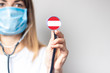 female doctor holding a stethoscope on a light background. Added flag of Austria. Concept medicine, level of medicine, virus, epidemic