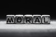 Conceptual inscription moral on metal cubes on a black gray background close-up isolated