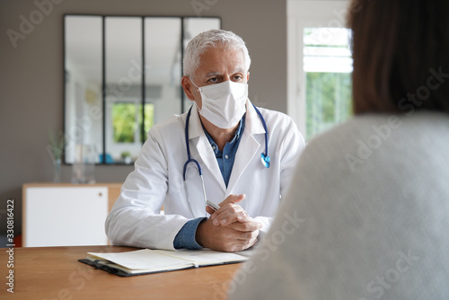 Doctor meeting with patient, wearing protection mask