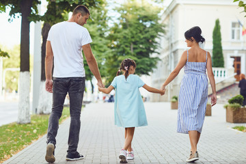 Happy family walking together in the street of the city