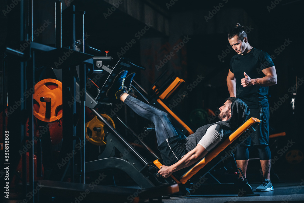 young man has workout with personal trainer in modern gym Stock Photo ...