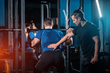 Wall Mural - young man has workout with personal trainer in modern gym