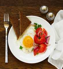 Wall Mural - Fried egg with tomato salad. Healthy breakfast. Selective focus