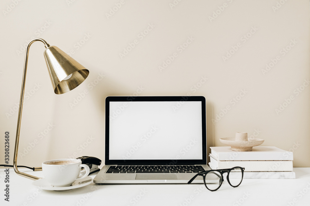 Blank screen laptop. Home office desk table workspace with coffee, lamp, glasses, notebook on beige background. Copy space mockup blog, website template. Blogger, outsourcing freelancer hero header. - obrazy, fototapety, plakaty 