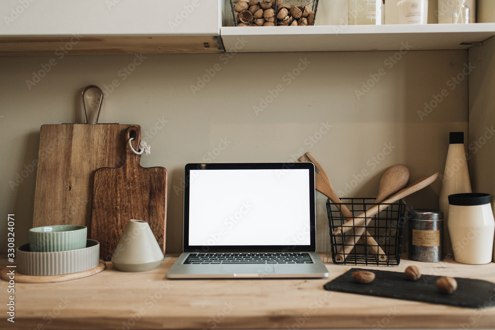 Kitchen workspace with blank copy space mock up laptop screen. Modern stylish kitchen interior design with wooden kitchenware. Front view blog, social media, website hero header template. - obrazy, fototapety, plakaty 