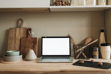 Wall Mural - Kitchen workspace with blank copy space mock up laptop screen. Modern stylish kitchen interior design with wooden kitchenware. Front view blog, social media, website hero header template.