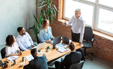 employer giving speech on meeting with employees sitting in office