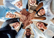 © Prostock-studio - Coworkers Standing In Circle Holding Hands During Meeting In Office