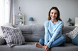 © BestForYou - Relaxed smiling woman sitting on sofa at home.