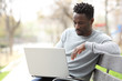 © PheelingsMedia - Serious black man using a laptop in a park