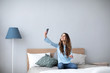 © BestForYou - Cute young woman looking at her smartphone.
