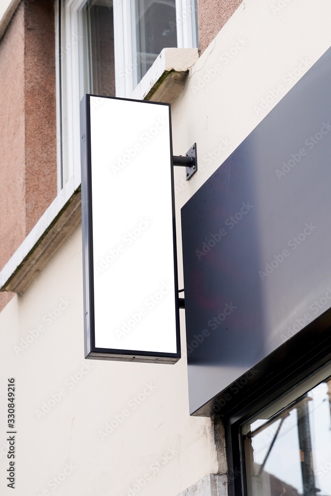vertical white signage on shop front street - obrazy, fototapety, plakaty 