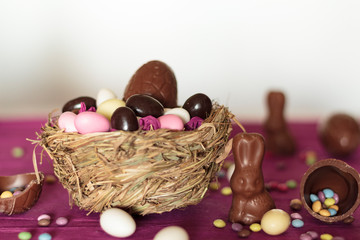 Wall Mural - Nest with chocolate eggs, chocolate bunny and sweets on easter table