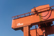 © Andy - Orange Crane in a construction site with the sky in the background in the daytime