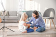 © Pixel-Shot - Private music teacher giving lessons to little girl at home