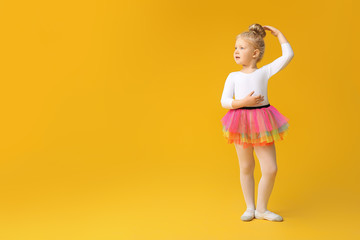 Cute little ballerina on color background