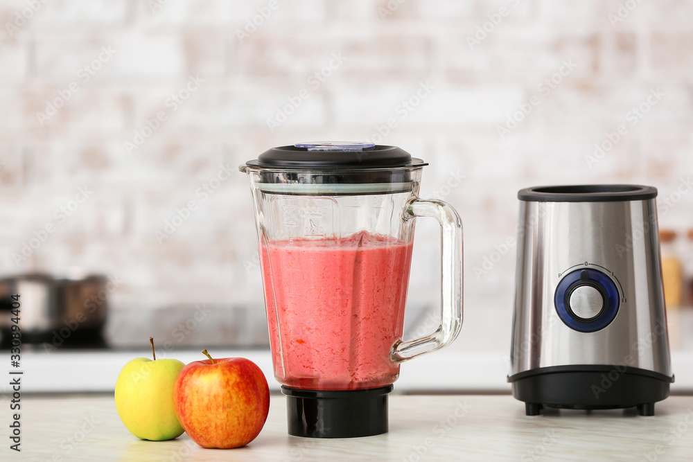 Blender with healthy smoothie on kitchen table