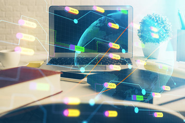 Double exposure of desktop with computer and world map hologram. International data network concept.