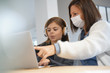© goodluz - Woman at home with kid helping with online teaching - coronavirus