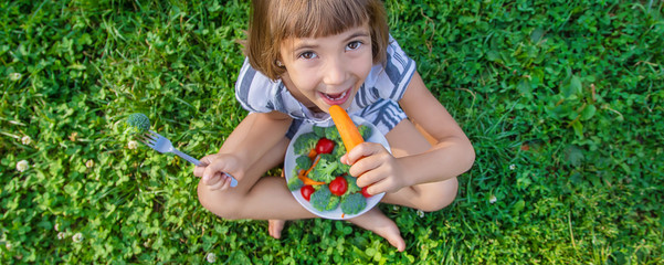 child eats vegetables broccoli and carrots. Selective focus.