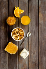 Wall Mural - Granola for healthy breakfast. Still life composition with fruits and toast on wooden background top-down