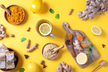 Wall Mural - Medical care concept. Cold, flu treatment. Ginger, lemon, honey, pills, drugs, supplements, thermometer on yellow background. Natural alternative holistic approach. Top view, copy space