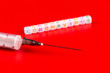 © satura_ - Pandemic and virus concept - Coronavirus text and syringe on red background. Novel coronavirus Covid-19.