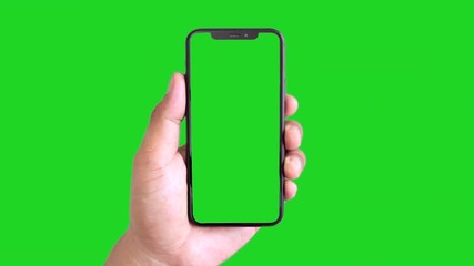 Man's hand holding a black smartphone with green screen and touching or press display, Man using mobile phone with chroma key touch display on green background.