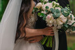 the bride holds a delicate wedding bouquet