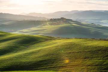 amazing spring landscape with green rolling hills and farm houses in the heart of tuscany in morning