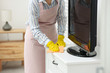 © New Africa - Young chambermaid wiping dust from furniture in hotel room, closeup