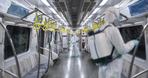Cuadros en Lienzo HazMat team in protective suits decontaminating metro car during virus outbreak