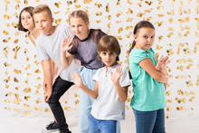 Room Decorated With Golden Decorations And Group Of Cool Kids Fooling Around And Making Funny Poses