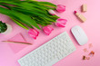 © Julia Klintsova - Woman's work place on pink background flat lay. Remote distant home office above, lockdown quarantine coronavirus protection. Female freelance indoor. Computer, tulip flowers birthday 8 march greeting