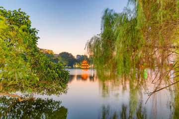 Wall Mural - Turtle Tower in the center of Hoan Kiem Lake(Lake of the Returned Sword) framed by trees. This tower is a popular tourist attraction in Hanoi, Vietnam