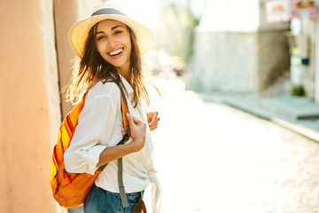 portrait joyful tourist woman walking ancient street, turning around to camera