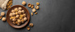 Nuts. Walnut kernels and whole walnuts on dark stone table. Black background. Top view, flat lay with copy space.