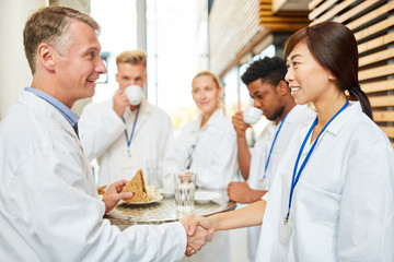 Wall Mural - Oberarzt begrüßt Medizin Studentin mit handshake