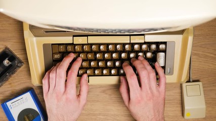 View from above of hands typing on an old vintage keyboard and using a retro mouse from 70s 80s computer timelapse. Old technology concept.
