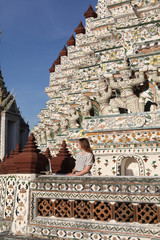 Look of fashion tourist girl and Wat Arun temple in Bangkok, Thailand. Beautiful old religious asian architecture. Bangkok ancient landmark and architectural monument. Street style, stylish woman