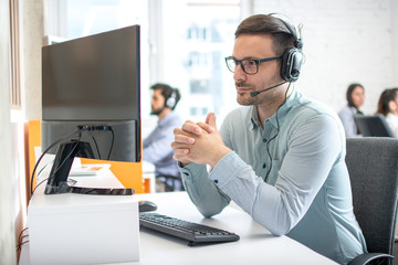 Wall Mural - Customer service support operator man with headphones and microphone listening to his client in call center