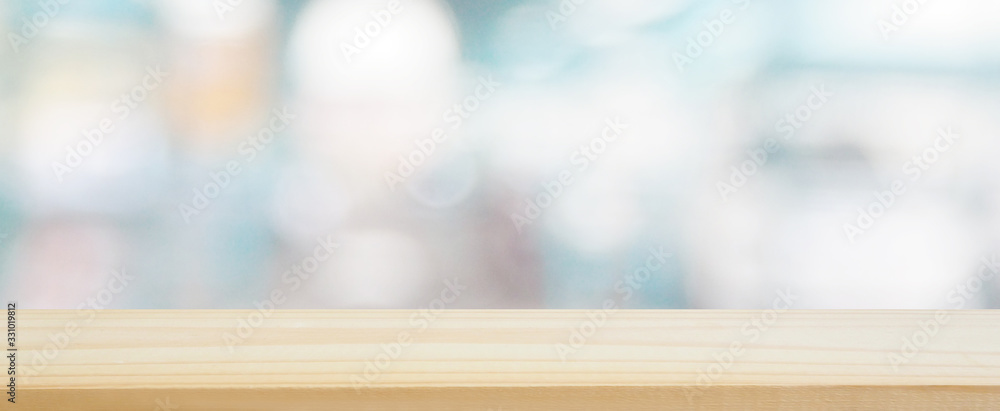 wood plank table top on blur and bokeh abstract in the department store with blue color tone using for design shopping background and banner montage display product layout - obrazy, fototapety, plakaty 