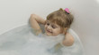 © Andrii Iemelianenko - Cute blonde girl takes a bath in swimwear. Little child, 4 years old. Hygiene