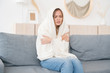 Upset young woman freezing, feeling cold at home, sitting on sofa covered with blanket