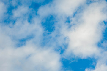 white fluffy clouds against a bright blue sky