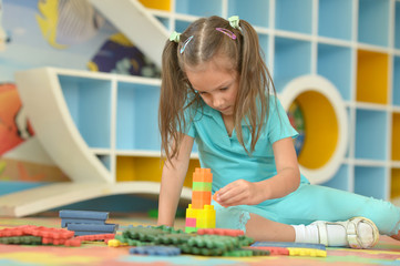 Poster - Little girl playing with colorful plastic blocks