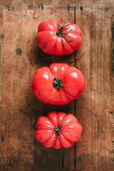 Wall Mural - Ugly tomatoes on wooden background. Concept of zero waste production. Top view. Copy space. Non gmo vegetables