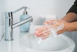Fototapeta  - Hygiene. Cleaning Hands. Washing hands with soap. Young woman washing hands with soap over sink in bathroom, closeup. Covid 19. Coronavirus.