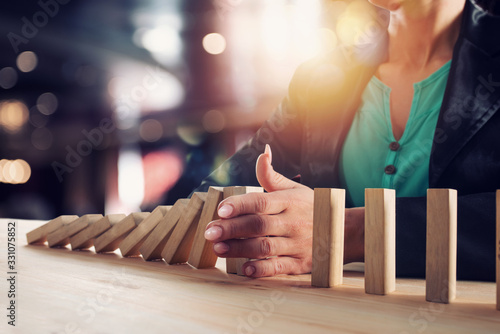 Fotografía Businesswoman stops a chain fall like domino game